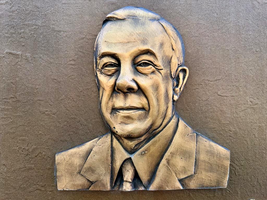 Brass embossed headshot of George P. Shultz